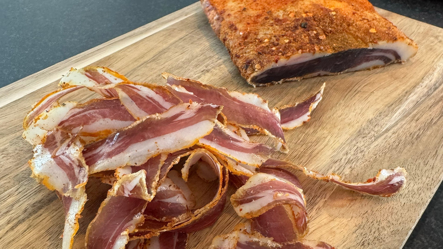 Slices wild boar Pancetta on a wooden board